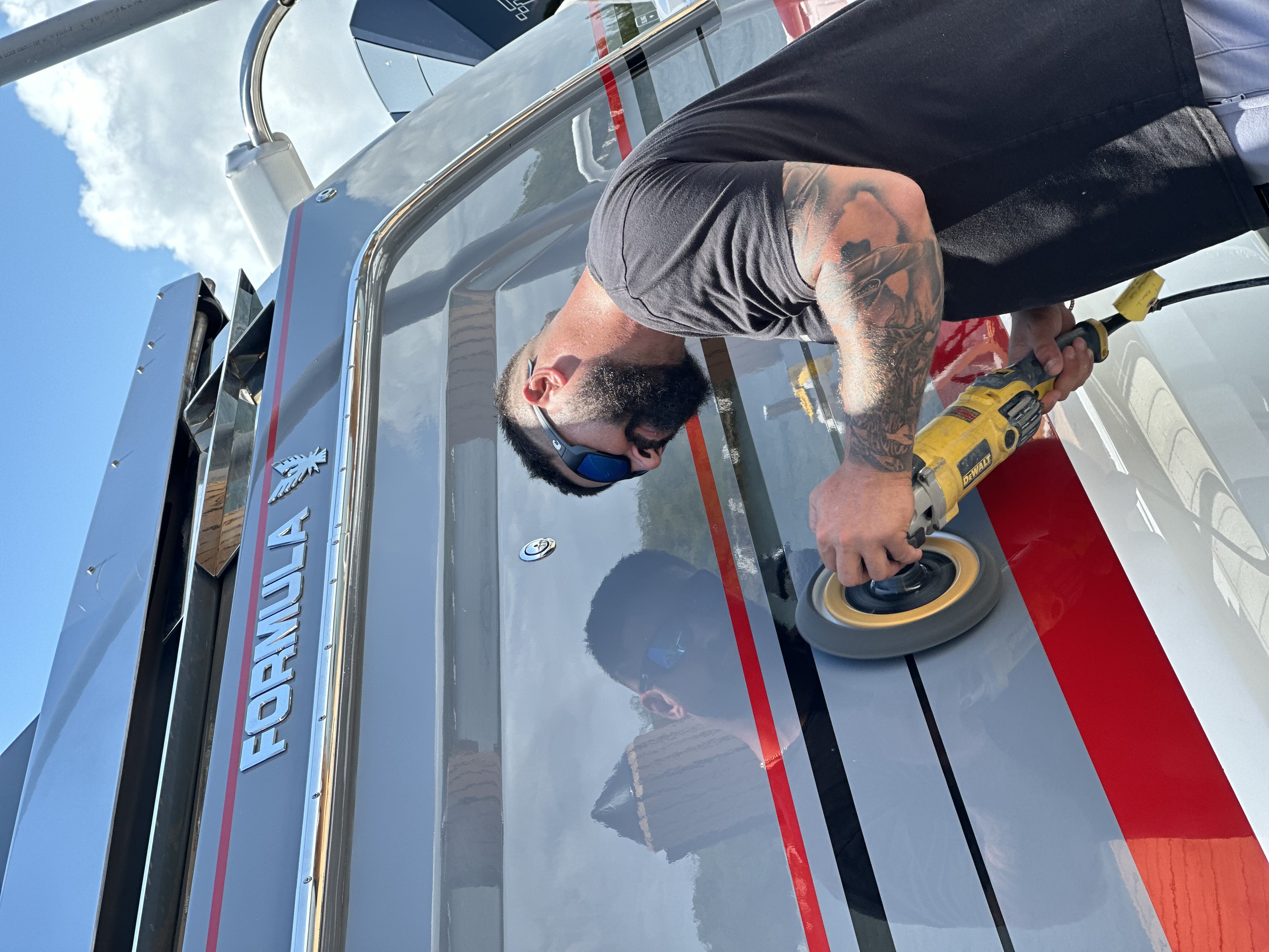 Captain Phil polishing the hull of a Formula boat
